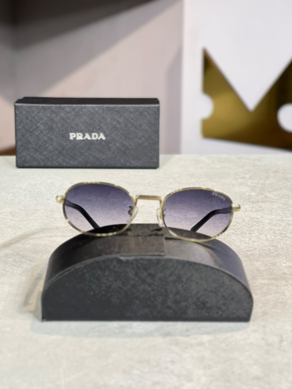 Gafas Prada ovalada dorada lente gris morado, vista frontal