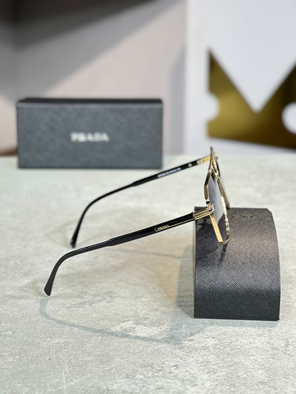 Gafas Prada optica negra dorada, perfil alterno